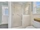 Tiled shower enclosure featuring glass door and tiled walls, next to a white toilet and exterior door at 16 Johnstone Ln., Georgetown, SC 29440