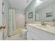 Clean bathroom with white vanity, shower and tub combination, and pastel green walls at 16 Johnstone Ln., Georgetown, SC 29440