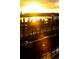 Golden hour shines on a waterfront scene with a wooden fence and boats on the water at 16 Johnstone Ln., Georgetown, SC 29440