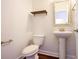 Small powder room with pedestal sink, toilet, and decorative mirror at 2117 Mirabel Ct., North Myrtle Beach, SC 29582