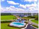 Aerial view of community pool and clubhouse surrounded by homes and beautiful green spaces at 2155 Gooseberry Way, Longs, SC 29568