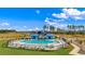Community pool with ample seating surrounded by green lawns and blue clubhouse in background at 2155 Gooseberry Way, Longs, SC 29568