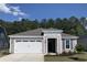 Charming single-story home featuring a two-car garage and manicured front yard with trees in the background at 2155 Gooseberry Way, Longs, SC 29568