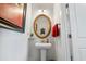 A powder room with a pedestal sink, rope-trimmed mirror, and modern lighting at 2404 Thoroughfare Dr. # 2404, North Myrtle Beach, SC 29582