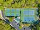 Aerial view of well-maintained tennis courts surrounded by lush trees and a parking area at 2404 Thoroughfare Dr. # 2404, North Myrtle Beach, SC 29582