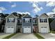 Charming new construction townhomes with individual garages, varied siding colors, and inviting curb appeal on a sunny day at 261 Christiana Ln. # B, Myrtle Beach, SC 29579
