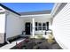 Inviting front porch with white columns, a bench, and potted plants at 262 Ole Maple St., Loris, SC 29569