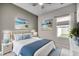 Bright bedroom featuring beach-themed wall art, ceiling fan, and a comfortable bed with blue accents at 352 High Falls Dr., Conway, SC 29526
