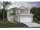 Two-story house with a green exterior, two-car garage, and landscaping at 4015 Braid Ct., Myrtle Beach, SC 29588