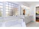 Relaxing bathroom with soaking tub, double vanity, and glass block window at 402 Ocean Pointe Ct., North Myrtle Beach, SC 29582