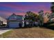 House exterior at sunset, palm trees, two-car garage at 402 Ocean Pointe Ct., North Myrtle Beach, SC 29582