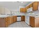 Kitchen with wood cabinets, white appliances, and tile flooring at 4432 Montrose Ln. # H, Myrtle Beach, SC 29579