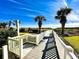 White walkway to beach, palm trees, and lush landscaping at 4505 S Ocean Blvd. S # 1-E, North Myrtle Beach, SC 29582