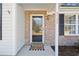 Inviting front entrance with brick accents, a glass door, and a 'Welcome Home' doormat at 5933 Rahnavard Blvd., Myrtle Beach, SC 29588
