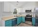 Bright kitchen featuring white cabinets, modern appliances, and stylish teal base cabinets at 5933 Rahnavard Blvd., Myrtle Beach, SC 29588