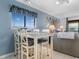 Condo dining area with glass-top table and four chairs near living room at 6000 N Ocean Blvd. # 317, North Myrtle Beach, SC 29582