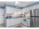 Condo kitchen with white cabinets, stainless steel appliances, and blue backsplash at 6000 N Ocean Blvd. # 317, North Myrtle Beach, SC 29582