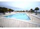 Large community pool surrounded by lounge chairs and palm trees offers a relaxing oasis at 6001-1709 South Kings Hwy., Myrtle Beach, SC 29575