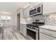 Modern kitchen with gray cabinets, granite countertops, and stainless steel appliances at 640 Woodside Dr., Conway, SC 29526