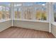 Sunroom with wood flooring and walls of windows offering wooded views at 670 2Nd Ave. N, North Myrtle Beach, SC 29582