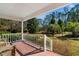 Relaxing front porch with brick flooring and white railings, overlooking a tree-lined yard at 7152 Highway 134, Conway, SC 29527