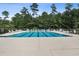 Community swimming pool with lounge chairs and surrounding trees at 858 Edgewater Dr., Murrells Inlet, SC 29576