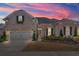 Brick home exterior at sunset, showcasing landscaping and a two-car garage at 860 Villarosa Dr., Myrtle Beach, SC 29572