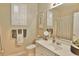 Bright bathroom features a large mirror, white cabinetry, and neutral colored tile and walls at 905 Adaline Ct., Myrtle Beach, SC 29579