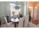 Traditional dining room with an elegant chandelier, decorative columns, and a sun-lit window at 905 Adaline Ct., Myrtle Beach, SC 29579