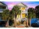 Two-story home with a brick driveway and palm trees at 116B 15Th Ave. N, Surfside Beach, SC 29575