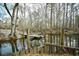 Wooden dock on calm waterway with boat and trees at 155 Busbee St., Conway, SC 29526