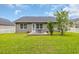 Backyard with a well-maintained lawn, patio, and mature landscaping at 184 Retreat Pl., Little River, SC 29566