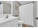 Clean bathroom with a white sink, toilet, and shower curtain at 184 Retreat Pl., Little River, SC 29566