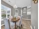 Inviting dining area featuring wood floors, modern chandelier, and sunlit windows, with a view into the kitchen at 184 Retreat Pl., Little River, SC 29566