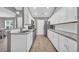 Modern kitchen featuring white cabinetry, granite countertops, stainless steel appliances, and wood flooring at 184 Retreat Pl., Little River, SC 29566