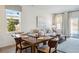 Inviting dining area adjacent to living room featuring a decorative light fixture, wood table, and ample natural light at 195 Talladega Dr. # 430, Myrtle Beach, SC 29579