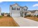 Two-story house with gray siding, a white garage door, and landscaping, near a pond at 3304 Candytuft Dr., Conway, SC 29526