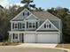 Charming two-story home with a two-car garage, classic black shutters, and light green siding at 558 Haven View Way, Murrells Inlet, SC 29576