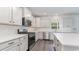 Stylish kitchen with white shaker cabinets, quartz countertops, stainless steel appliances, and wood-look flooring at 558 Haven View Way, Murrells Inlet, SC 29576