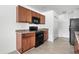 Kitchen features dark wood cabinets, black appliances, and tile floor at 605 West Perry Rd., Myrtle Beach, SC 29579