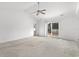 Bright main bedroom with carpet, sliding glass door to patio, and ceiling fan at 605 West Perry Rd., Myrtle Beach, SC 29579