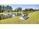 Two park benches sit beside a tranquil pond at 623 Meadowgrass Ct., Myrtle Beach, SC 29588