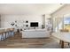 Open-concept living space with light, neutral colors, modern furnishings, a kitchen bar, and a TV at 705 Choctaw Dr., Conway, SC 29526