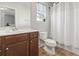 Cozy bathroom featuring a single sink vanity with a wooden cabinet and a toilet with a shower and curtain at 817 Old Castle Loop, Myrtle Beach, SC 29579