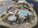 Aerial view of a community pool with a separate hot tub and a playground that's surrounded by luscious palm trees at 817 Old Castle Loop, Myrtle Beach, SC 29579