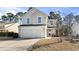 Inviting exterior elevation with attached two-car garage and cozy front porch seating area on a sunny day at 817 Old Castle Loop, Myrtle Beach, SC 29579