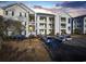 Exterior shot of the building, highlighting well-lit balconies and parking in front of this multi-story condo building at 901 West Port Dr. # 1706, North Myrtle Beach, SC 29582