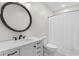Bathroom with updated vanity, round mirror, toilet, and shower with curtain at 1020 Thomas Ave., North Myrtle Beach, SC 29582
