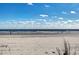 Picturesque beach scene with sandy shore and calm ocean waters under a bright sky at 1201 Possum Trot Rd., North Myrtle Beach, SC 29582