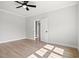 Neutral bedroom featuring light wood floors, a ceiling fan, white trim and an open door at 1201 Possum Trot Rd., North Myrtle Beach, SC 29582